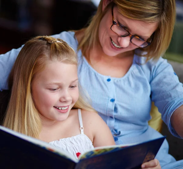 我最喜欢的书他们读书时 一个可爱的小女孩坐在她妈妈旁边 — 图库照片