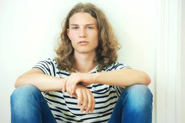 私は私が誰であるか インディースタイル 木の床に座っている巻き毛の長い髪の若い男 — ストック写真