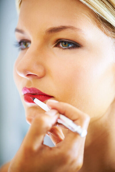 Lip perfection. Closeup shot of a young woman having lipstick applied to her lips