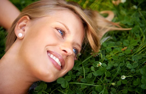 コンテンツの夏 草の上に横たわる魅力的な若い女性が — ストック写真
