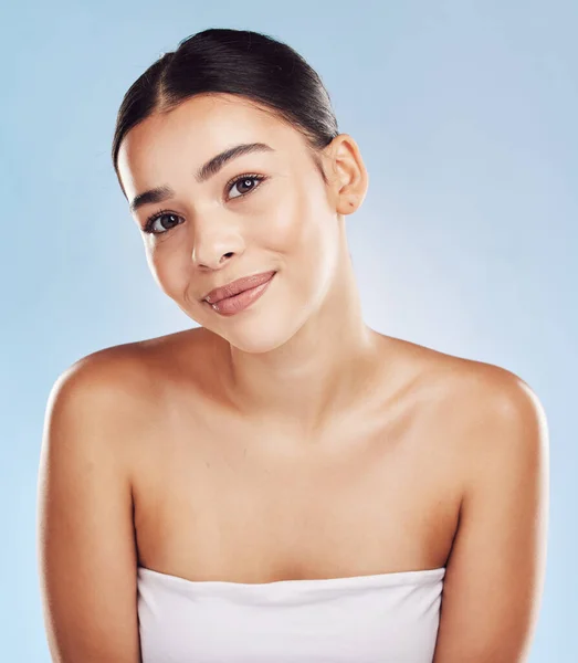 Closeup face beautiful young mixed race woman. An attractive female posing in studio isolated against a blue background. A skincare regime that keeps your skin soft, smooth, glowing and healthy.
