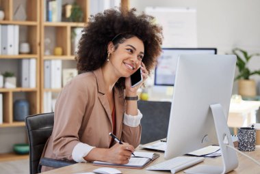 Genç melez, kıvırcık saçlı, bilgisayar başında çalışan, cep telefonuyla konuşan ve ofiste notlar yazan bir iş kadını. Bir kadın sadece planları yönetmek ve teslim tarihlerini tamamlamak için birden fazla iş yapıyor..