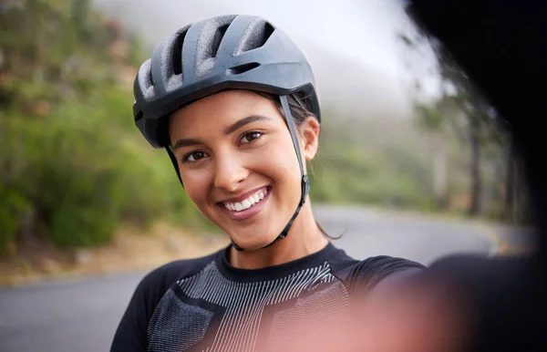 外でのサイクリングからの休憩中に自撮りした幸せな笑顔の混合レース運動の若い女性の肖像 ヘルメットをかぶってスポーツフィット混合レースの女性と彼女自身の写真を撮る — ストック写真