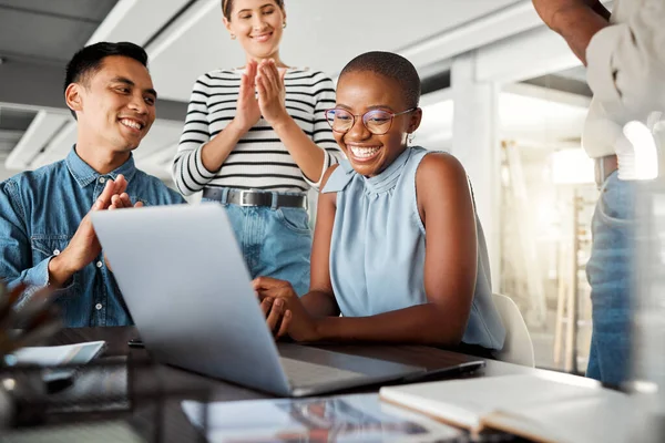 Group of diverse businesspeople having a meeting in an office at work. Happy business professionals clapping for their colleagues achievement together. Joyful african american businesswoman being app.