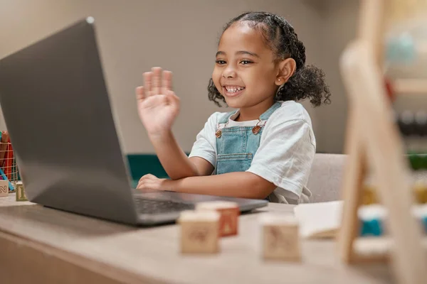 stock image Child, waving or laptop video call for homeschool education, e learning support or lockdown class in house or home living room. Smile, happy or greeting hand gesture for student on technology webinar.