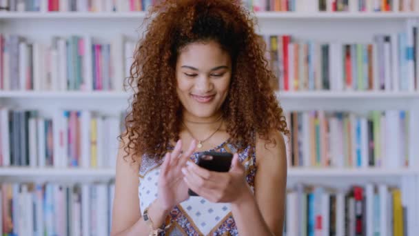 メキシコの奨学金入学のための電子メールアプリに電話ニュースを持つ図書館 女性と学生 興奮し 大学の教育機会のインターネットの更新と通知を持つジェンZの女の子 — ストック動画