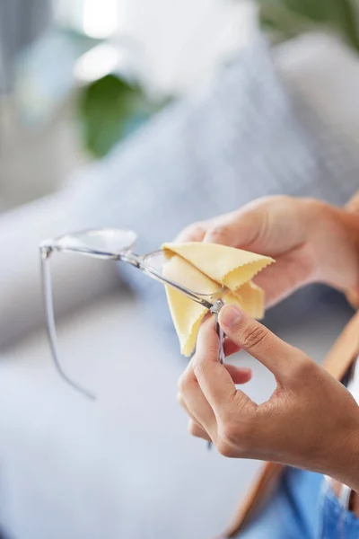 stock image Cleaning, glasses and dust with hands of woman for dirt, disinfection and ophthalmology. Fabric, frame and microfiber tissue with girl wipe spectacles lens for eye care, optometrist or antibacterial.