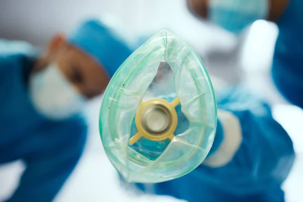 Closeup oxygen mask, ventilation and doctors in hospital of emergency healthcare, surgery or medicine in operating room. Breathing machine, ventilator and air for patient, lungs and medical operation.