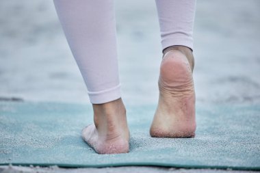 Woman in yoga stretching feet at a beach training legs in a holistic foot exercise or workout in nature. Fitness, wellness or spiritual zen girl exercising for balance or healthy strong body alone. clipart