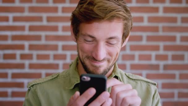 Mand Smartphone Skrive Mobil App Med Mursten Væg Baggrund Byen – Stock-video