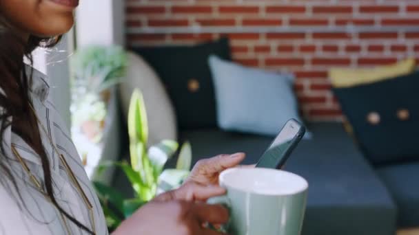 咖啡和思考黑人妇女与电话社交媒体 阅读电子邮件和网络交流 在创业期间 通过茶和手机与网络 聊天和非洲员工取得联系 — 图库视频影像
