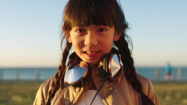 아시아 어린이 그리고 바다나 스타일 헤드폰 사용하는 초상화 발리의 환경에서의 — 비디오