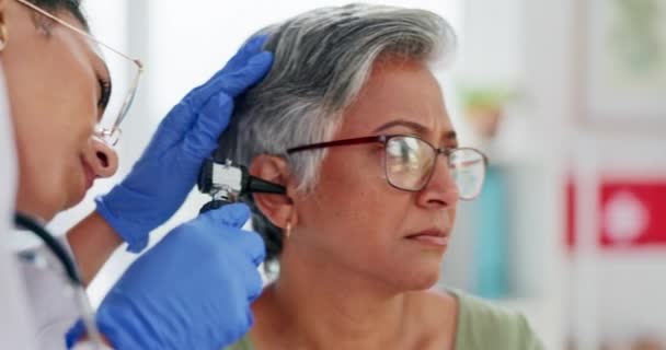 高齢者および耳の検査 病院での補聴器または診断のための検査または医療検査 耳鼻咽喉科医の手と聴診器はクリニックで聴覚医療のためのシニア女性を助ける — ストック動画