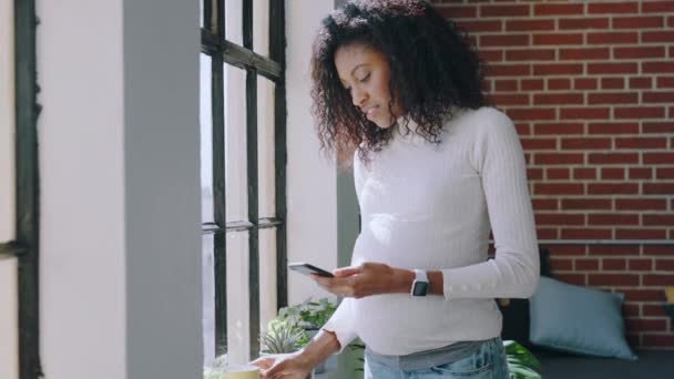 Έγκυος Μαύρη Γυναίκα Καφέ Και Τηλέφωνο Από Παράθυρο Στα Μέσα — Αρχείο Βίντεο