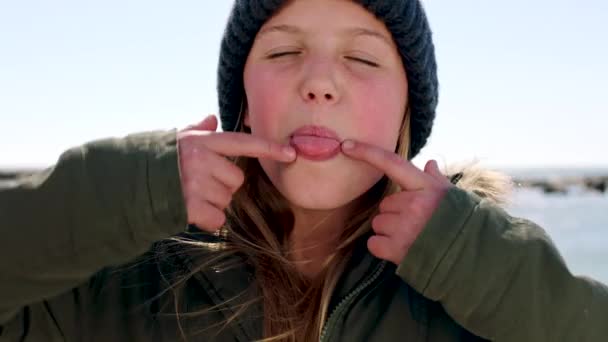 Kind Gesicht Und Glückliches Mädchen Strand Mit Winterkleidung Und Zunge — Stockvideo