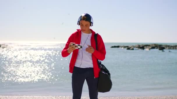 Plaj Akıllı Telefon Kulaklıklı Adam Sosyal Medya Paylaşımı Profil Fotoğrafı — Stok video
