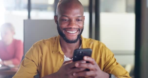 ソーシャルメディアや電子メール ニュースやコンテンツ作成者の投稿を読むためのオンライン中に黒人男性 電話やオフィスのチャット Webサイトのプロジェクト研究のためのデスクで従業員の顔に笑顔 — ストック動画