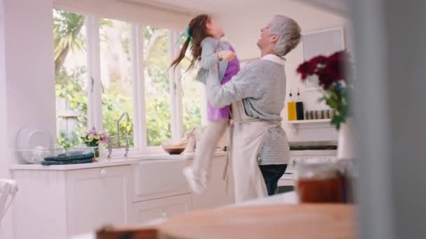 訪問中に自宅のキッチンで一緒に女の子と祖母の絆で家族 愛と興奮しています 家の中で抱き合っている年配の女性と女性の孫を持つ幸せな笑顔と子供たち — ストック動画
