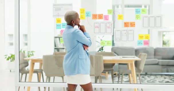 贴心的笔记和在办公室的黑人女性的想法 商务会议和战略 有创意的工作场所 计划和深思熟虑的女工 并在玻璃墙上贴上便条 — 图库视频影像