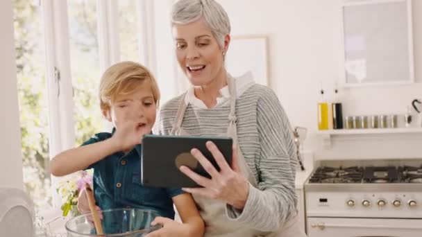 おばあちゃん 男の子 ビデオは キッチン または家で一緒に焼くときにタブレットで呼び出します 幸せなシニアおばあちゃん 興奮した子供と料理ながら話 波と笑顔でデジタル技術ズームコール — ストック動画