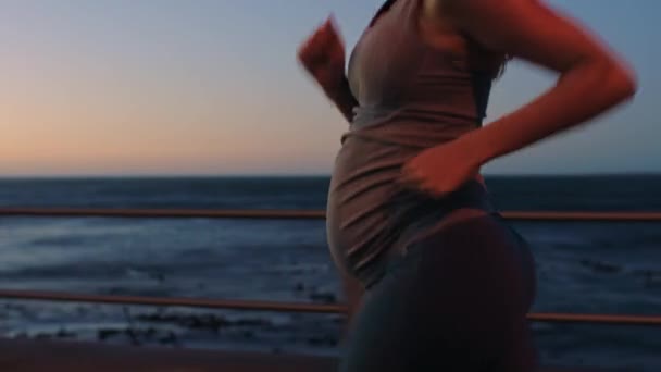 ランニング 妊娠中の女性と健康と健康のための屋外でのワークアウト 心臓トレーニングのための夜の海の遊歩道 海の見える妊娠中のフィットネスのために実行中の女性 — ストック動画
