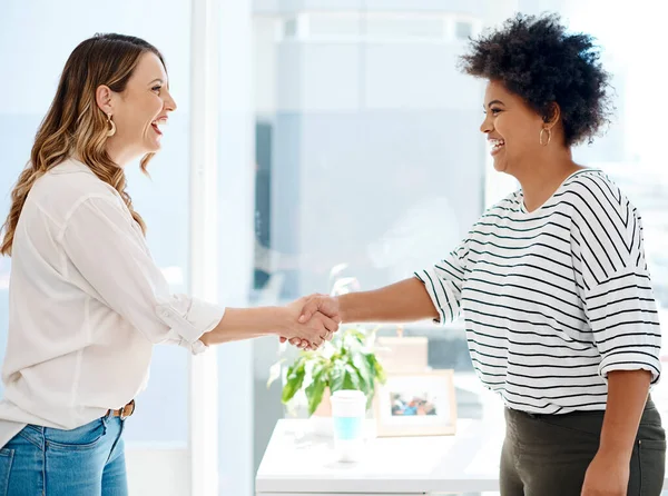 Its always a pleasure doing business with you. two attractive young businesswomen shaking hands together inside an office