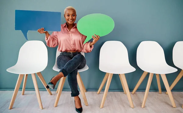 You can also join in the conversation. Studio portrait of an attractive young businesswoman holding up speech bubbles while sitting in line against a grey background