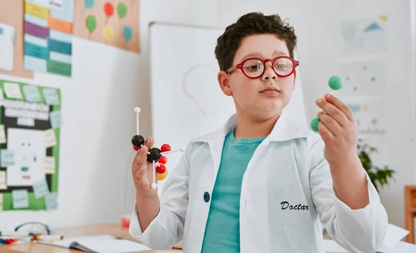 科学の中で最も重要なことのほとんど 学校の理科の授業で分子の勉強をしている可愛い少年が — ストック写真
