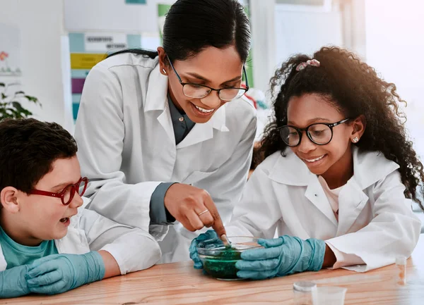 Science is our type of magic. two adorable young school pupils experimenting and making slime with their science teacher at school