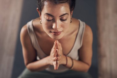 İç huzurun her şeyden önce gelmeli. Çekici bir genç kadın evde meditasyon yapıyor ve yoga yapıyor.