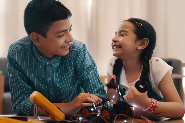 We always have fun when we work together. two adorable young siblings building a robotic toy car together at home