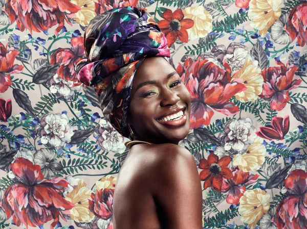 Rocking her head wrap. Studio shot of a beautiful young woman wearing a traditional African head wrap against a floral background
