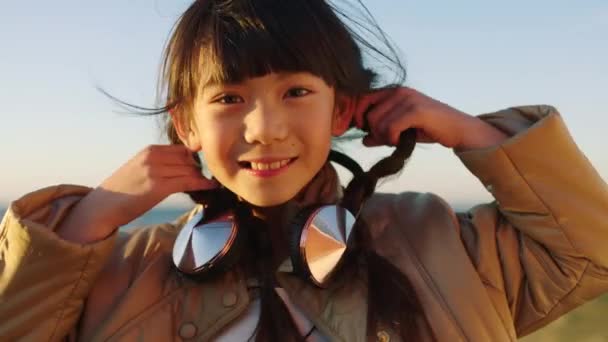 女の子 子供や旅行やヘッドフォン 髪や屋外の楽しさ 幸福と笑顔で顔や音楽に耳を傾ける アジアの子供の肖像画とオンラインストリーミングで日本の若い ジェンZと冒険 — ストック動画