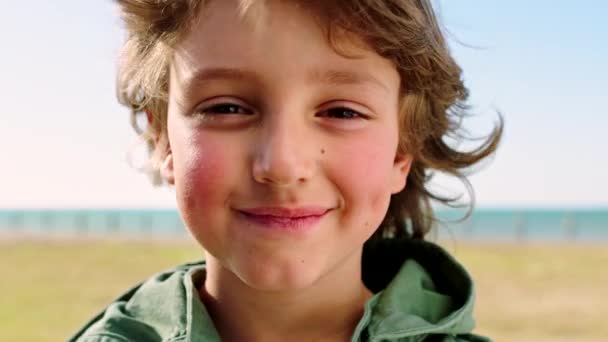 自由と健康のための興奮した笑顔でビーチでの子供の旅行 幸せと顔 カリフォルニアで太陽の光を楽しむ若い男の子のリラックスした 幸福と休暇 米国の肖像画ズーム — ストック動画