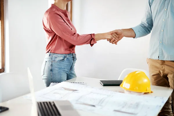 Its a pleasure doing business with you. two unrecognizable businesspeople shaking hands in agreement over building plans in the office
