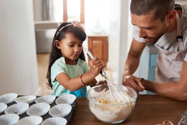 Shes such a natural when it comes to baking. a young man baking at home with his young daughter