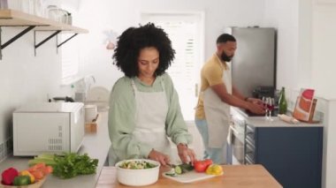 Öpüşme, yemek pişirme ve şarap ile siyah çift tost yaparken lezzetli ve sağlıklı salata için sebze kesme. Aşk, yemek ve romantik erkek ve kadın yemek hazırlarken mutfakta alkolle tezahürat yapıyor