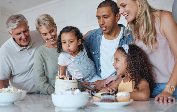 Big family, birthday cake and blowing candles for a wish at home with parents, grandparents and children together for a celebration. Men, women and kids in UK house to celebrate at party for a girl.