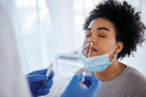 Covid, health and medical test with black woman, nasal swab and doctor with patient, healthcare and face mask. Sample collection for PCR, diagnosis and health care, covid 19 compliance and safety