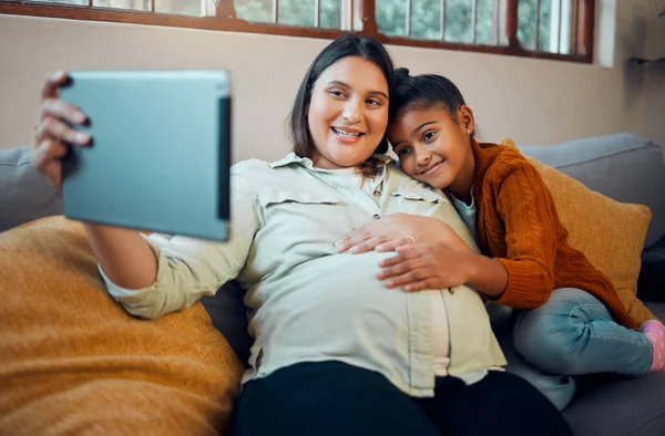 Pregnant mother, girl or tablet on video call on sofa in house or home living room in lockdown communication, social media or selfie. Smile, happy or pregnant mom and bonding child on zoom technology.