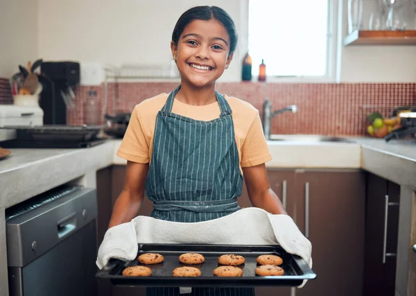Baking, cookies and girl portrait happy about food, learning and youth helping in the kitchen and home. Cooking, house and child baker with a proud smile and happiness from making a kid dessert.
