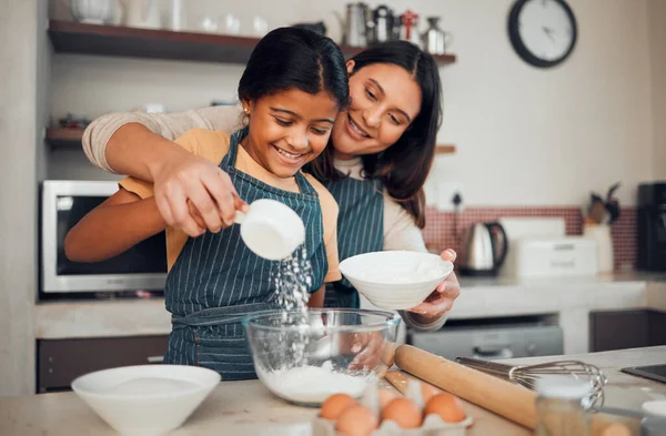 Family, baking and helping with food in home kitchen with mother and daughter learning to make dessert with wheat flour and eggs. Happy woman teaching girl kid about cooking for fun bonding.