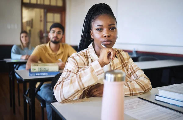 University, education and thinking with a student black woman in class during a lecture or lesson for learning. Study, school or scholarship with a female pupil sitting in a classroom for development.
