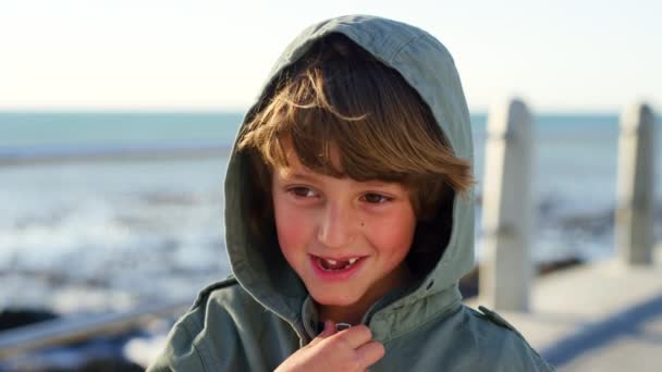 快乐的男孩 海滩和脸上带着微笑 帽衫和快乐的散步 假期和户外阳光 年轻的男孩 在迈阿密度假的时候 在模糊的背景下漫步在人行道上和海浪中 — 图库视频影像
