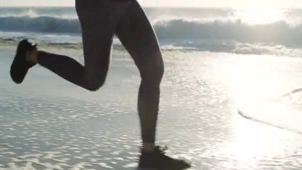 ワークアウトの屋外 マラソントレーニングのモチベーションと心臓運動のための足のランニング フィットネスやビーチの波 アスリート 強いランナーの足とオーストラリアの海の砂のコストスポーツウェルネス — ストック動画