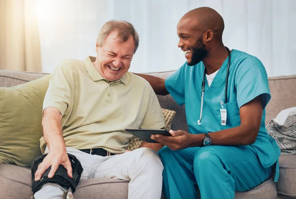 Rehabilitation, knee pain and man and nurse with tablet for recovery results, patient report and scan at home. Healthcare, support and happy medical worker with senior man laughing in consultation.