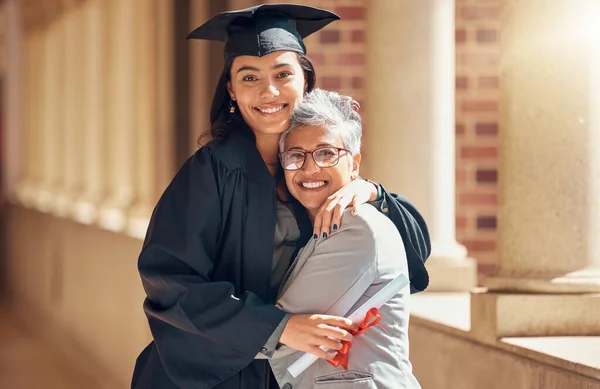 stock image Graduation, university and portrait of mother with girl at academic ceremony, celebration and achievement. Family, education and mom hugging graduate daughter with degree or diploma on college campus.