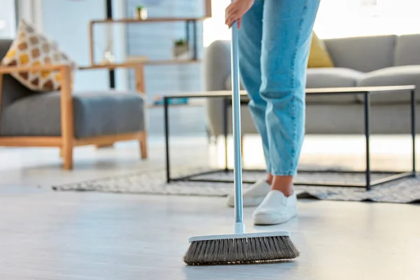 Cleaning, woman with broom and sweeping living room dirty floor and spring cleaning. Housekeeper, cleaner and housekeeping service or home maintenance for fresh, neat and dust free house or apartment.