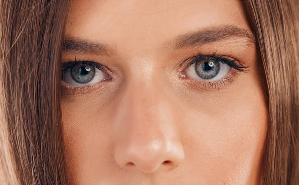 Woman, eyes and face in vision for sight, beauty or awareness staring with facial cosmetics or makeup. Closeup portrait of female looking in eyesight, skincare or microblading eyebrows and eyelashes.