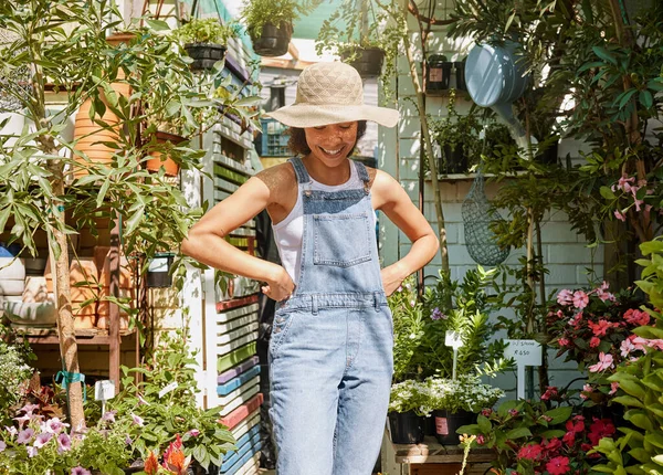 Gardening, plants and black woman happy working in flowers retail supermarket, nature agriculture and standing in small business shop. Gardener, smile and proud girl in greenhouse for herbs ecology.